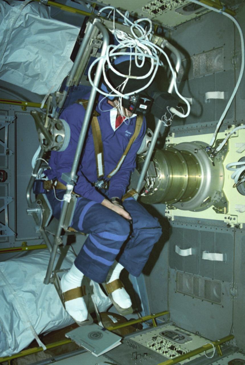Astronaut David C. Hilmers conducts the Microgravity Vestibular Investigations (MVI) sitting in its rotator chair inside the IML-1 science module. When environmental conditions change so that the body receives new stimuli, the nervous system responds by interpreting the incoming sensory information differently. In space, the free-fall environment of an orbiting spacecraft requires that the body adapts to the virtual absence of gravity. Early in flights, crewmembers may feel disoriented or experience space motion sickness. MVI examined the effects of orbital flight on the human orientation system to obtain a better understanding of the mechanisms of adaptation to weightlessness. By provoking interactions among the vestibular, visual, and proprioceptive systems and then measuring the perceptual and sensorimotor reactions, scientists can study changes that are integral to the adaptive process. The IML-1 mission was the first in a series of Shuttle flights dedicated to fundamental materials and life sciences research with the international partners. The participating space agencies included: NASA, the 14-nation European Space Agency (ESA), the Canadian Space Agency (CSA), the French National Center of Space Studies (CNES), the German Space Agency and the German Aerospace Research Establishment (DAR/DLR), and the National Space Development Agency of Japan (NASDA). Both life and materials sciences benefited from the extended periods of microgravity available inside the Spacelab science module in the cargo bay of the Space Shuttle Orbiter. Managed by the Marshall Space Flight Center, IML-1 was launched on January 22, 1992 aboard the Space Shuttle Orbiter Discovery (STS-42 mission).