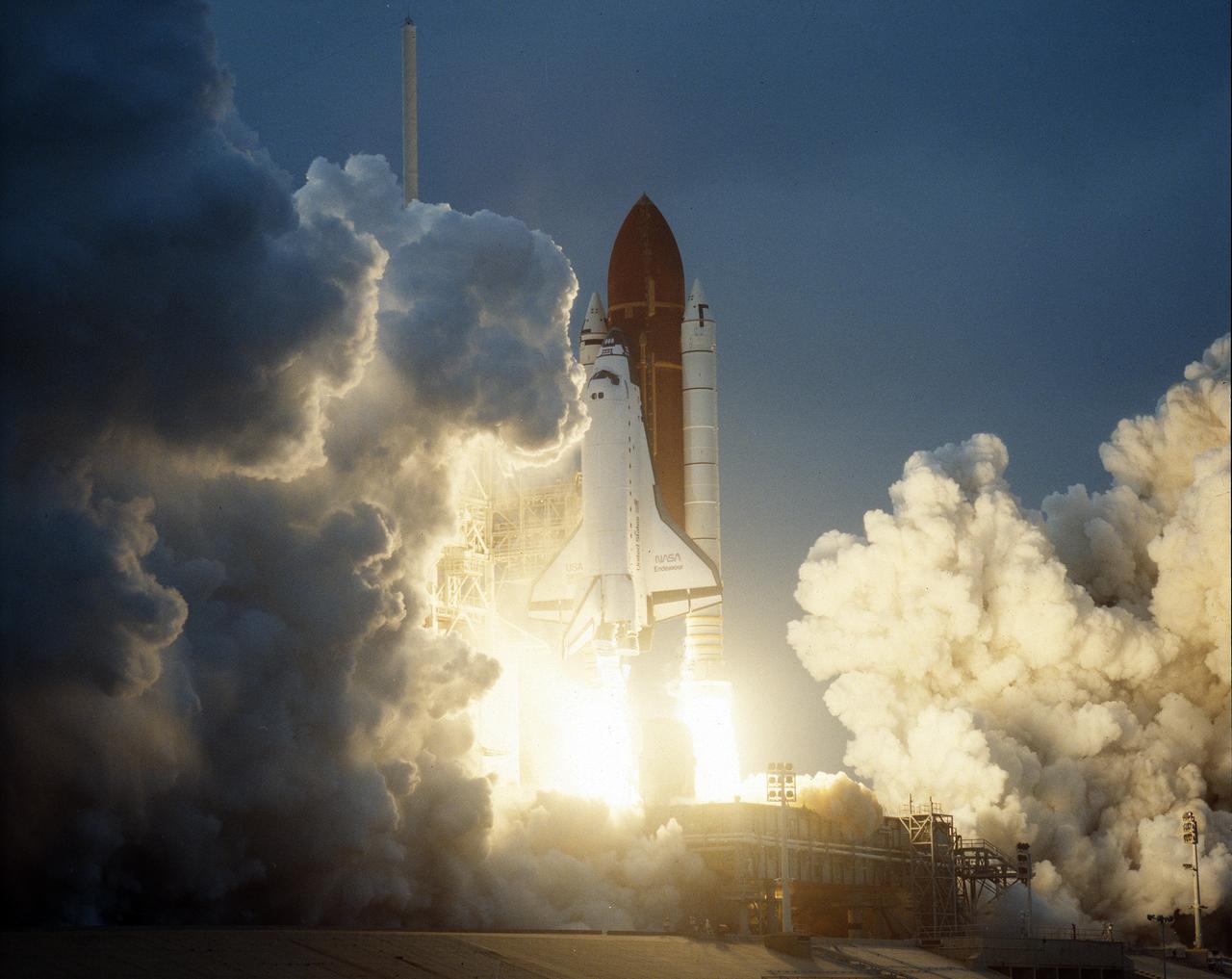 STS-49, the first flight of the Space Shuttle Orbiter Endeavour, lifted off from launch pad 39B on May 7, 1992 at 6:40 pm CDT. The STS-49 mission was the first U.S. orbital flight to feature 4 extravehicular activities (EVAs), and the first flight to involve 3 crew members working simultaneously outside of the spacecraft. The primary objective was the capture and redeployment of the INTELSAT VI (F-3) which was stranded in an unusable orbit since its launch aboard the Titan rocket in March 1990.