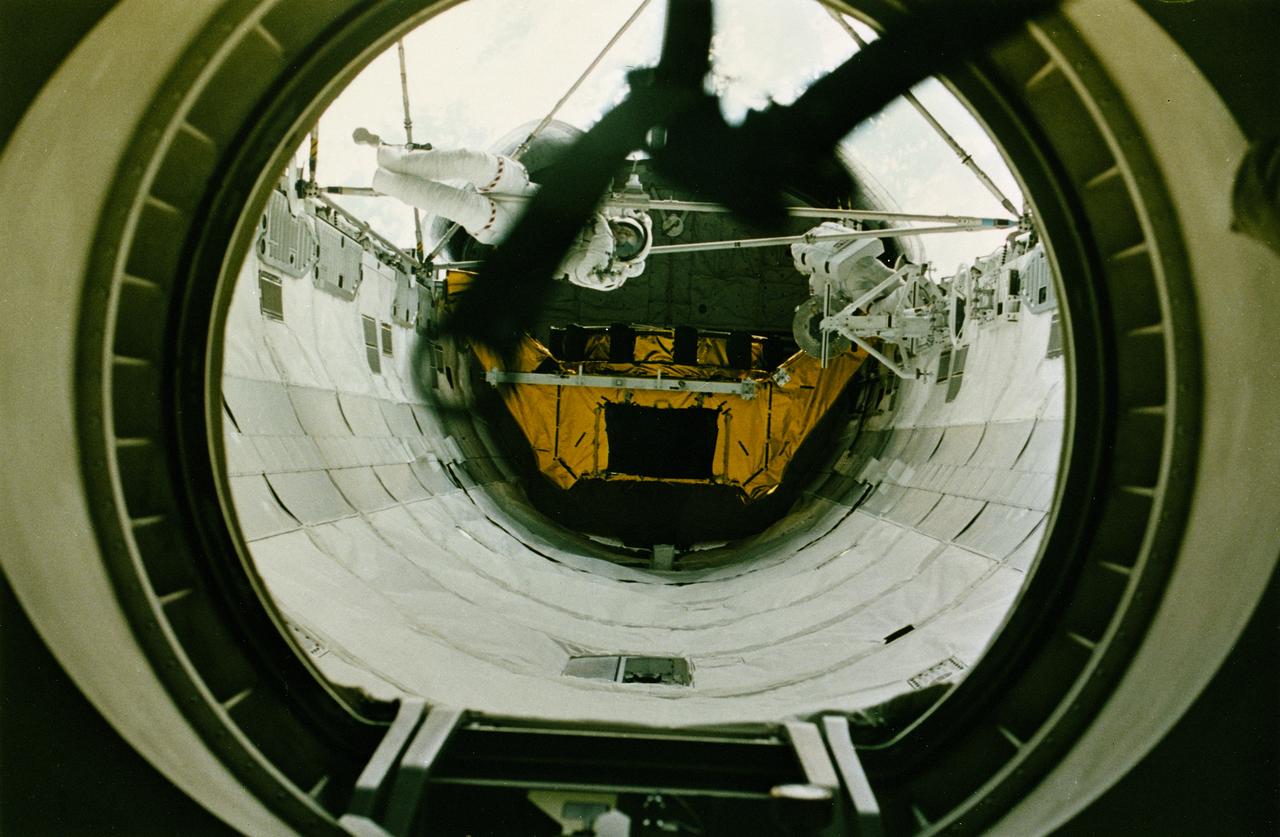 STS-49, the first flight of the Space Shuttle Orbiter Endeavour, lifted off from launch pad 39B on May 7, 1992 at 6:40 pm CDT. The STS-49 mission was the first U.S. orbital flight to feature 4 extravehicular activities (EVAs), and the first flight to involve 3 crew members working simultaneously outside of the spacecraft. The primary objective was the capture and redeployment of the INTELSAT VI (F-3), a communication satellite for the International Telecommunication Satellite organization, which was stranded in an unusable orbit since its launch aboard the Titan rocket in March 1990. A view through Endeavour’s busy airlock reveals astronauts Thomas Akers and Kathryn Thornton. 