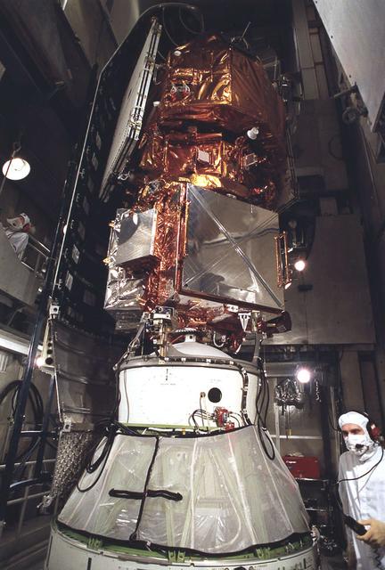 At Launch Complex 17 Pad A, Kennedy Space Center (KSC) workers are installing the payload fairing around the Extreme Ultraviolet Explorer (EUVE) mated to a Delta II rocket. The EUVE spacecraft is designed to study the extreme ultraviolet portion of the spectrum.