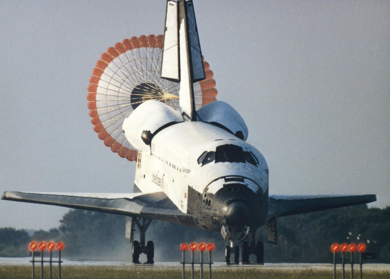 As the orbiter Columbia (STS-50) rolled down Runway 33 of Kennedy Space Center's (KSC) Shuttle Landing Facility, its distinctively colored drag chute deployed to slow down the spaceship. This landing marked OV-102's first end-of-mission landing at KSC and the tenth in the program, and the second shuttle landing with the drag chute. Edwards Air Force Base, CA, was the designated prime for the landing of Mission STS-50, but poor weather necessitated the switch to KSC after a one-day extension of the historic flight. STS-50 was the longest in Shuttle program historyo date, lasting 13 days, 19 hours, 30 minutes and 4 seconds. A crew of seven and the USML-1 were aboard.