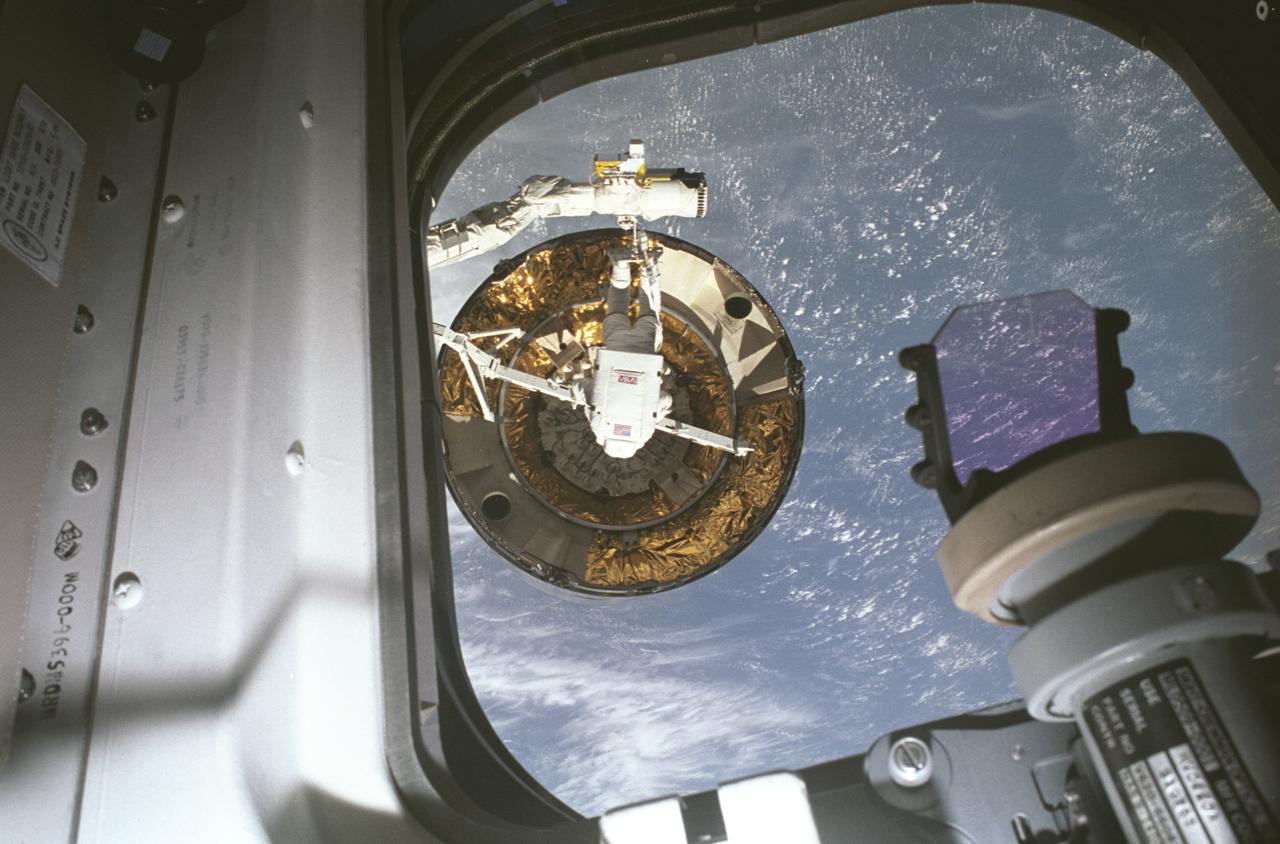 STS-49, the first flight of the Space Shuttle Orbiter Endeavour, lifted off from launch pad 39B on May 7, 1992 at 6:40 pm CDT. The STS-49 mission was the first U.S. orbital flight to feature 4 extravehicular activities (EVAs), and the first flight to involve 3 crew members working simultaneously outside of the spacecraft. The primary objective was the capture and redeployment of the INTELSAT VI (F-3), a communication satellite for the International Telecommunication Satellite organization, which was stranded in an unusable orbit since its launch aboard the Titan rocket in March 1990. Recorded with a 35 mm camera inside Endeavour’s cabin, is astronaut Pierre Thuot after his second unsuccessful attempt to affix a specially designed grapple bar to the 4.5 ton INTELSAT VI.  