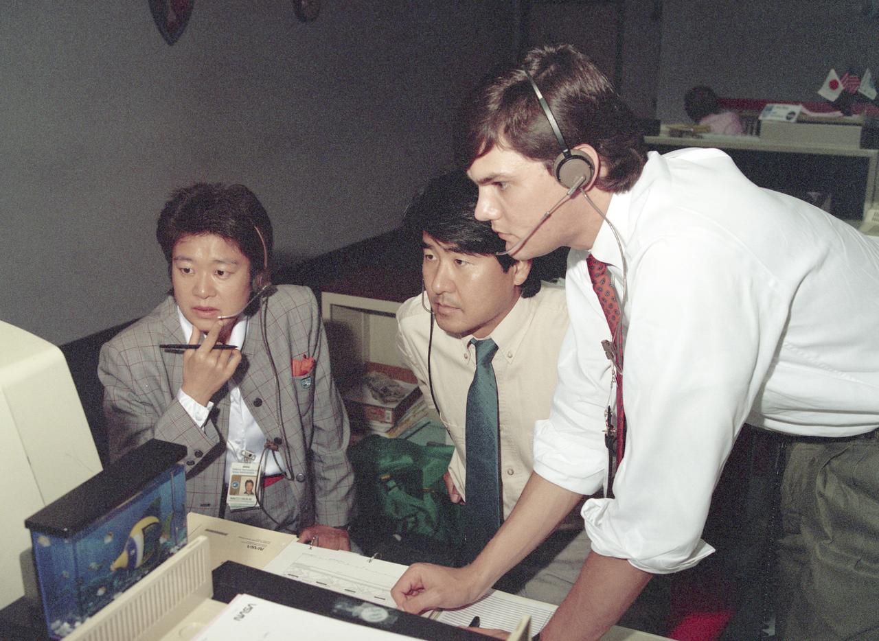 The science laboratory, Spacelab-J (SL-J), flown aboard the STS-47 flight was a joint venture between NASA and the National Space Development Agency of Japan (NASDA) utilizing a manned Spacelab module. The mission conducted 24 materials science and 20 life science experiments, of which 35 were sponsored by NASDA, 7 by NASA, and two collaborative efforts. Materials science investigations covered such fields as biotechnology, electronic materials, fluid dynamics and transport phenomena, glasses and ceramics, metals and alloys, and acceleration measurements. Life sciences included experiments on human health, cell separation and biology, developmental biology, animal and human physiology and behavior, space radiation, and biological rhythms. Test subjects included the crew, Japanese koi fish (carp), cultured animal and plant cells, chicken embryos, fruit flies, fungi and plant seeds, and frogs and frog eggs. Pictured along with George Norris in the Huntsville Operations Support Center (HOSC) Spacelab Payload Operations Control Center (SL POCC) at Marshall Space Flight Center (MSFC) are NASDA alternate payload specialists Dr. Doi and Dr. Mukai.