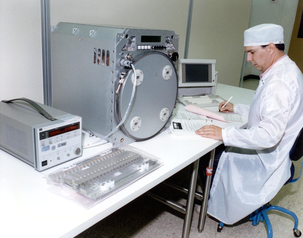MSFC Test Engineer performing a functional test on the TES. The TES can be operated as a refrigerator, with a minimum set point temperature of 4.0 degrees C, or as an incubator, with a maximum set point temperature 40.0 degrees C of the set point. The TES can be set to maintain a constant temperature or programmed to change temperature settings over time, internal temperature recorded by a date logger.