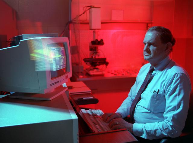 A NASA scientist operates the image analyzer to determine if telescope mirrors have become contaminated in the Materials and Processes lab at Marshall.