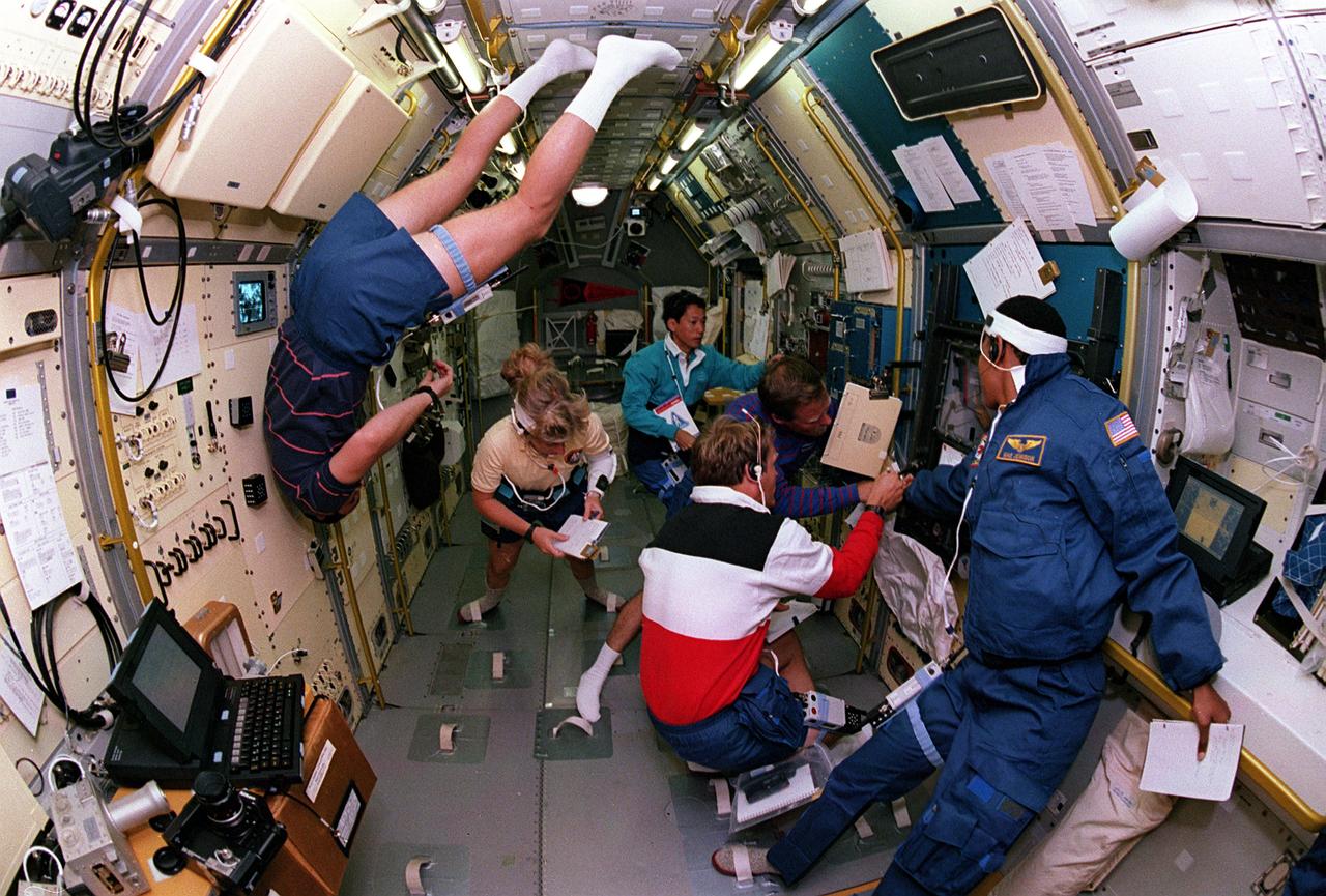 Space Shuttle Endeavour (STS-47) onboard photo of crew members working in the Spacelab-J module.