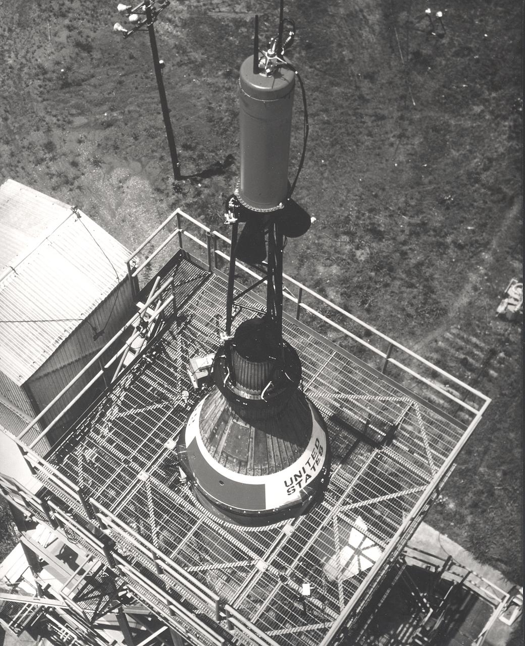 This photograph depicts installation of the Mercury capsule and escape system on top of a booster prior to test firing of the Mercury-Redstone launch vehicle at the Marshall Space Flight Center.