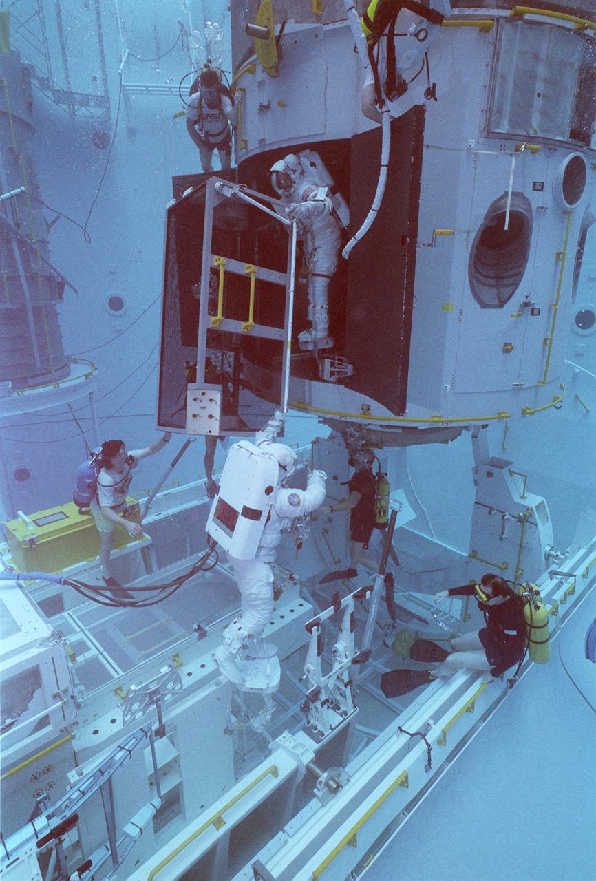 This photograph shows an STS-61 astronaut training for the Hubble Space Telescope (HST) servicing mission (STS-61) in the Marshall Space Flight Center's (MSFC's) Neutral Buoyancy Simulator (NBS). Two months after its deployment in space, scientists detected a 2-micron spherical aberration in the primary mirror of the HST that affected the telescope's ability to focus faint light sources into a precise point. This imperfection was very slight, one-fiftieth of the width of a human hair. A scheduled Space Service servicing mission (STS-61) in 1993 permitted scientists to correct the problem. The MSFC NBS provided an excellent environment for testing hardware to examine how it would operate in space and for evaluating techniques for space construction and spacecraft servicing.