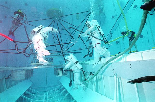 Astronauts Mark Lee and Mike Gerhardt, and a technician participate in the Nitrox breathing system test in Marshall's Neutral Buoyancy Simulator (NBS).