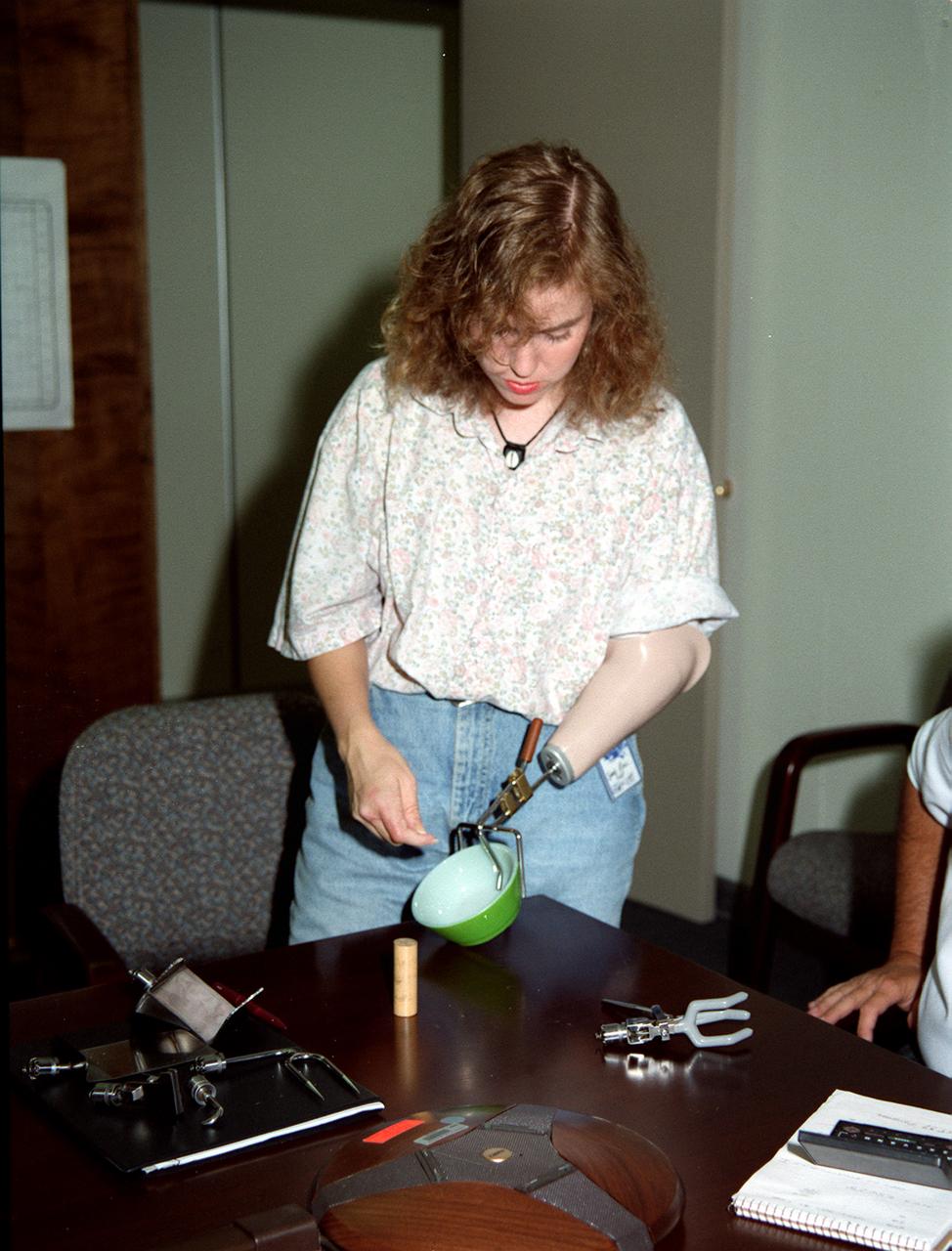 In this photograph, Sandra Rossi user her NASA-developed prosthesis for the first time. Derived from foam insulation technology used to protect the Space Shuttle External Tank from excessive heat, FAB/CAD, a subsidiary of the Harshberger Prosthetic and Orthotic Center, utilized the technology to replace the heavy, fragile plaster they used to produce master molds for prosthetics. The new material was lighter, cheaper and easier to manufacture than plaster, resulting in lower costs to the customer.
