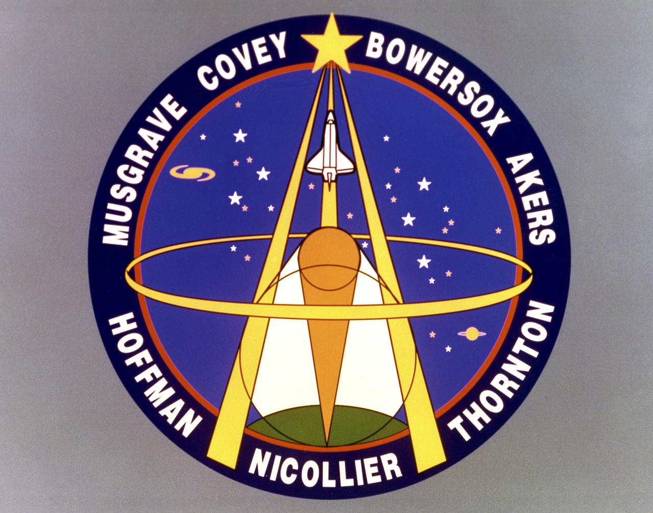 Designed by the mission crew members, the STS-61 crew insignia depicts the astronaut symbol superimposed against the sky with the Earth underneath. Also seen are two circles representing the optical configuration of the Hubble Space Telescope (HST). Light is focused by reflections from a large primary mirror and a smaller secondary mirror. The light is analyzed by various instruments and, according to the crew members, brings to us on Earth knowledge about planets, stars, galaxies and other celestial objects, allowing us to better understand the complex physical processes at work in the universe. The Space Shuttle Endeavour is also represented as the fundamental tool that allows the crew to perform the first servicing of the Hubble Space Telescope so its scientific deep space mission may be extended for several years to come. The overall design of the emblem, with lines converging to a high point, is also a symbolic representation of the large-scale Earth-based effort which involves space agencies, industry, and the universities to reach goals of knowledge and perfection. 