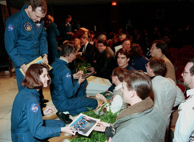 STS-61 astronauts Kathryn Thornton, Jeffrey Hoffman and Thomas Akers (standing) sign autographs in Marshall Space Flight Center's Morris Auditorium, January 19, 1994. Space Shuttle crews traditionally visited NASA field centers following each mission to present mission highlights and recognize employees who made contributions to the Shuttle program. Many of the techniques used during the STS-61 Hubble Space Telescope Servicing mission were rehearsed at the Center's Neutral Buoyancy Simulator. 
