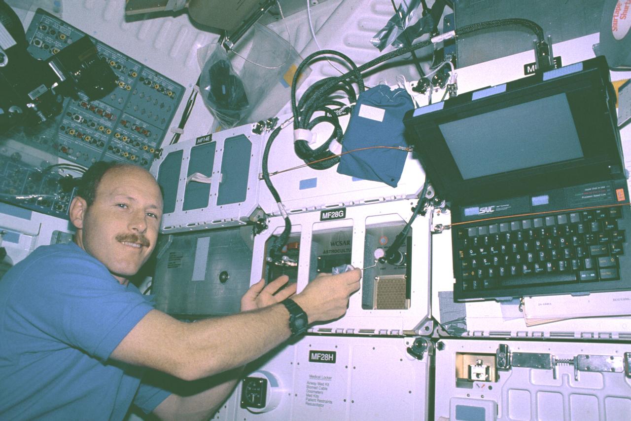 The first United States Microgravity Laboratory (USML-1) was one of NASA's science and technology programs that provided scientists an opportunity to research various scientific investigations in a weightless environment inside the Spacelab module. It also provided demonstrations of new equipment to help prepare for advanced microgravity research and processing aboard the Space Station. The USML-1 flew in orbit for extended periods, providing greater opportunities for research in materials science, fluid dynamics, biotechnology (crystal growth), and combustion science. This photograph shows astronaut Ken Bowersox conducting the Astroculture experiment in the middeck of the orbiter Columbia. This experiment was to evaluate and find effective ways to supply nutrient solutions for optimizing plant growth and avoid releasing solutions into the crew quarters in microgravity. Since fluids behave differently in microgravity, plant watering systems that operate well on Earth do not function effectively in space. Plants can reduce the costs of providing food, oxygen, and pure water as well as lower the costs of removing carbon dioxide in human space habitats. The Astroculture experiment flew aboard the STS-50 mission in June 1992 and was managed by the Marshall Space Flight Center.