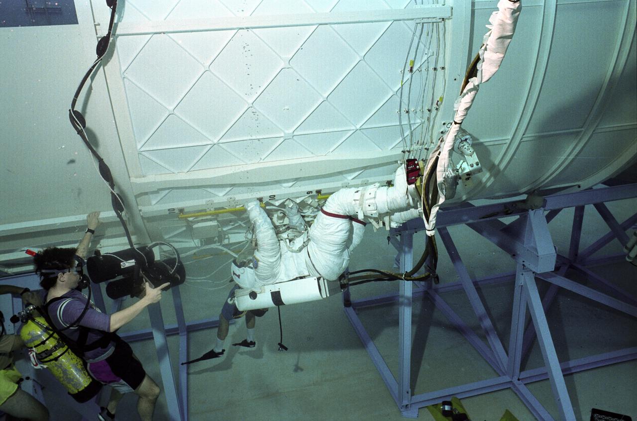 Astronauts Tamara Jernigan (#1) and David Wolf (#2) are training in the Neutral Buoyancy Simulator (NBS) at Marshall Space Flight center with an exercise for International Space Station Alpha. The NBS provided the weightless environment encountered in space needed for testing and the practices of Extravehicular Activities (EVA).