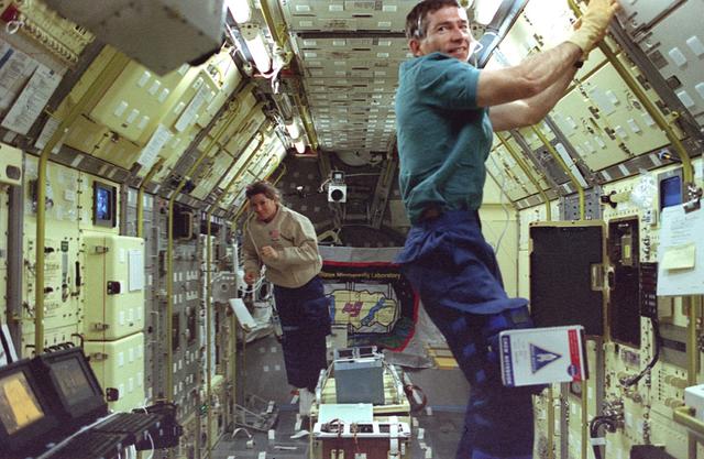 Onboard photo of space shuttle Columbia (STS-73) crewmembers Fred Leslie (foreground) and Catherine Coleman aboard the United States Microgravity Laboratory (USML) conducting experiments in a microgravitational environment available in the Orbiter's cargo bay while in low earth orbit.