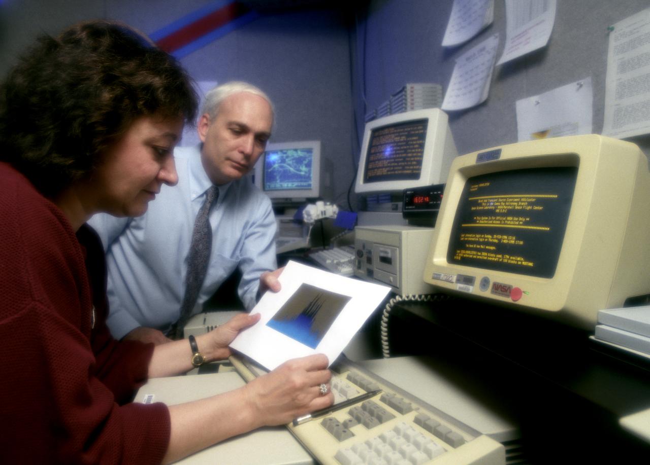 In this photograph, Dr. Gerald Fishman of the Marshall Space Flight Center (MSFC), a principal investigator of the Compton Gamma-Ray Observatory's (GRO's) instrument, the Burst and Transient Source Experiment (BATSE), and Dr. Chryssa Kouveliotou of Universities Space Research Associates review data from the BATSE. For nearly 9 years, GRO's Burst and Transient Source Experiment (BATSE), designed and built by the Marshall Space Flight Center, kept a blinking watch on the universe to alert scientist to the invisible, mysterious gamma-ray bursts. By studying gamma-rays from objects like black holes, pulsars, quasars, neutron stars, and other exotic objects, scientists could discover clues to the birth, evolution, and death of stars, galaxies, and the universe. The gamma-ray instrument was one of four major science instruments aboard the Compton. It consisted of eight detectors, or modules, located at each corner of the rectangular satellite to simultaneously scan the entire universe for bursts of gamma-rays ranging in duration from fractions of a second to minutes. Because gamma-rays are so powerful, they pass through conventional telescope mirrors. Instead of a mirror, the heart of each BATSE module was a large, flat, transparent crystal that generated a tiny flash of light when struck by a gamma-ray. With an impressive list of discoveries and diverse accomplishments, BATSE could claim to have rewritten astronomy textbooks. Launched aboard the Space Shuttle Orbiter Atlantis during the STS-35 mission in April 1991, the GRO reentered the Earth's atmosphere and ended its successful 9-year mission in June 2000.