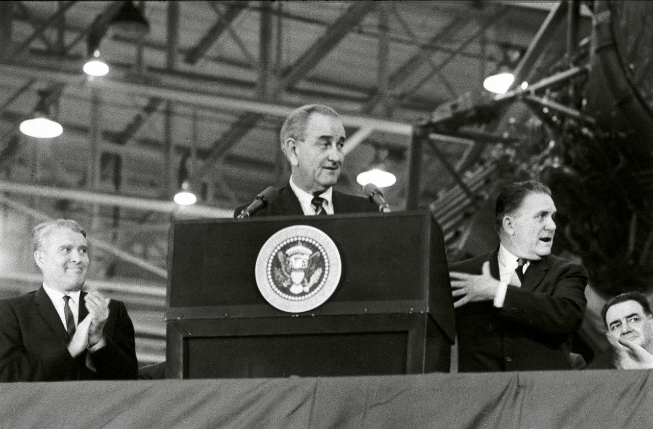 Marshall Space Flight Center (MSFC) Director Dr. Wernher von Braun (left) applauds President Lyndon Johnson's remarks during an address to 26,000 workers at the MSFC Michoud Assembly Facility on December 13, 1967. At right is NASA Administrator James Webb. 