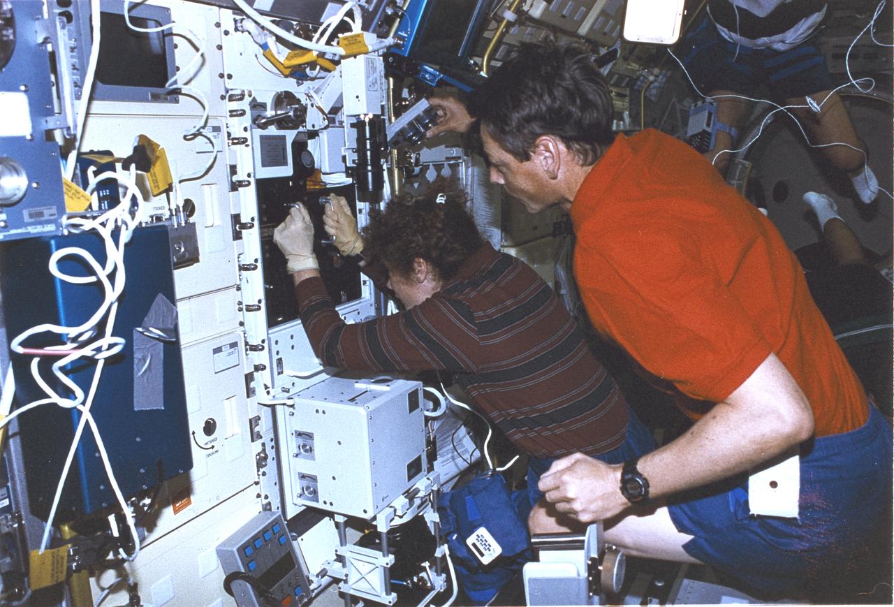 Launched on June 20, 1996, the STS-78 mission’s primary payload was the Life and Microgravity Spacelab (LMS), which was managed by the Marshall Space Flight Center (MSFC). During the 17 day space flight, the crew conducted a diverse slate of experiments divided into a mix of life science and microgravity investigations. In a manner very similar to future International Space Station operations, LMS researchers from the United States and their European counterparts shared resources such as crew time and equipment. Five space agencies (NASA/USA, European Space Agency/Europe (ESA), French Space Agency/France, Canadian Space Agency /Canada, and Italian Space Agency/Italy) along with research scientists from 10 countries worked together on the design, development and construction of the LMS. This onboard photo represents payload commander Susan Helms and fellow astronaut in the LMS.