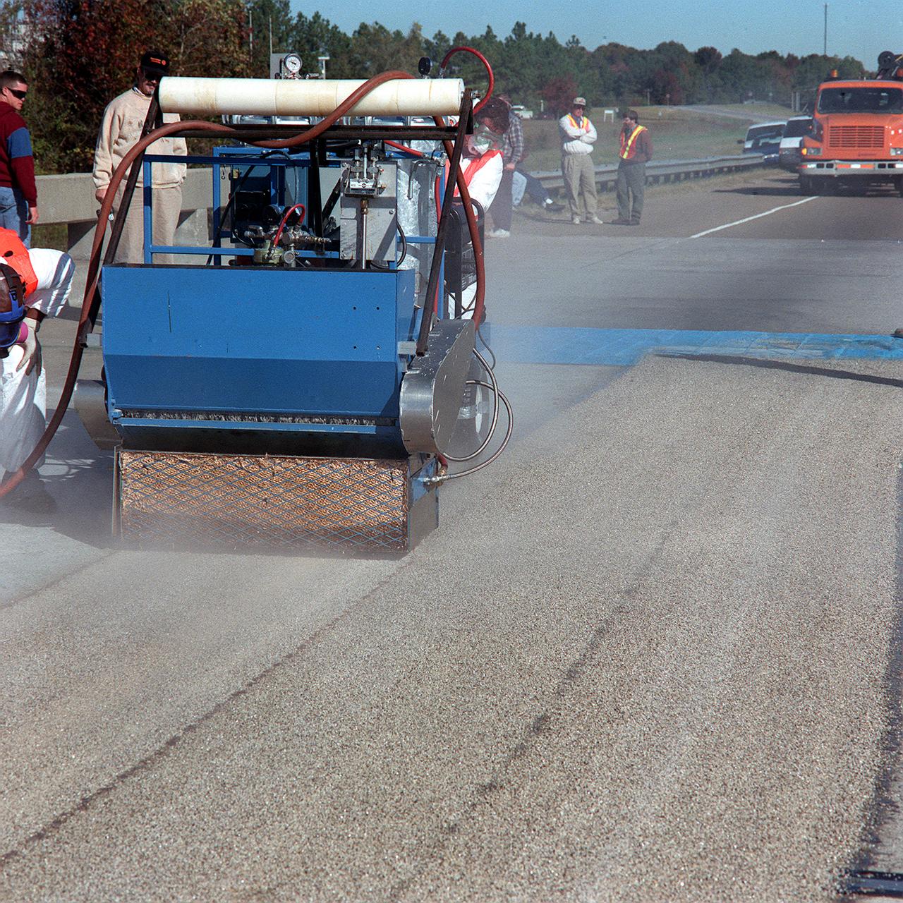 Alabama Department of Transportation workers utilize Convergent Spray Technology to resurface a bridge on Interstate 65 near Lacon, Alabama. Originally developed by USBI to apply a heat resistant coating to the Space Shuttle's Solid Rocket Boosters, the environment-friendly technology reduces the required worktime from days to hours.