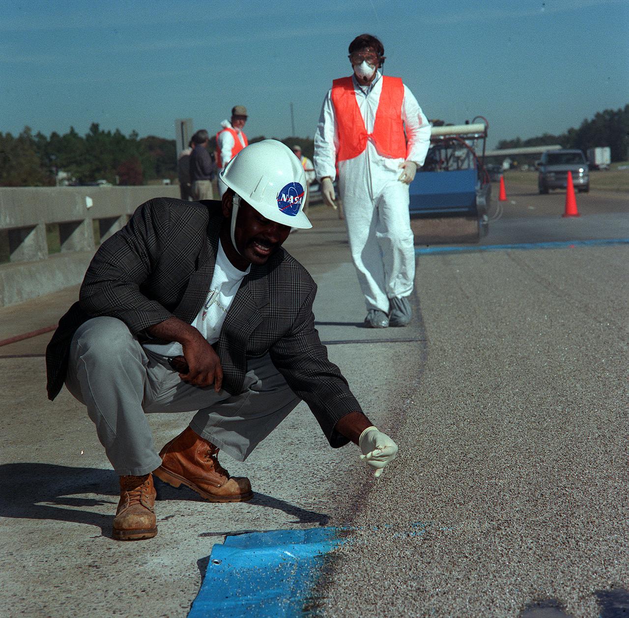 A NASA official inspects the results of Convergent Spray Technology used to resurface a bridge on Interstate 65 near Lacon, Alabama. Originally developed by USBI to apply a heat resistant coating to the Space Shuttle's Solid Rocket Boosters, the environment-friendly technology reduces the required worktime from days to hours.