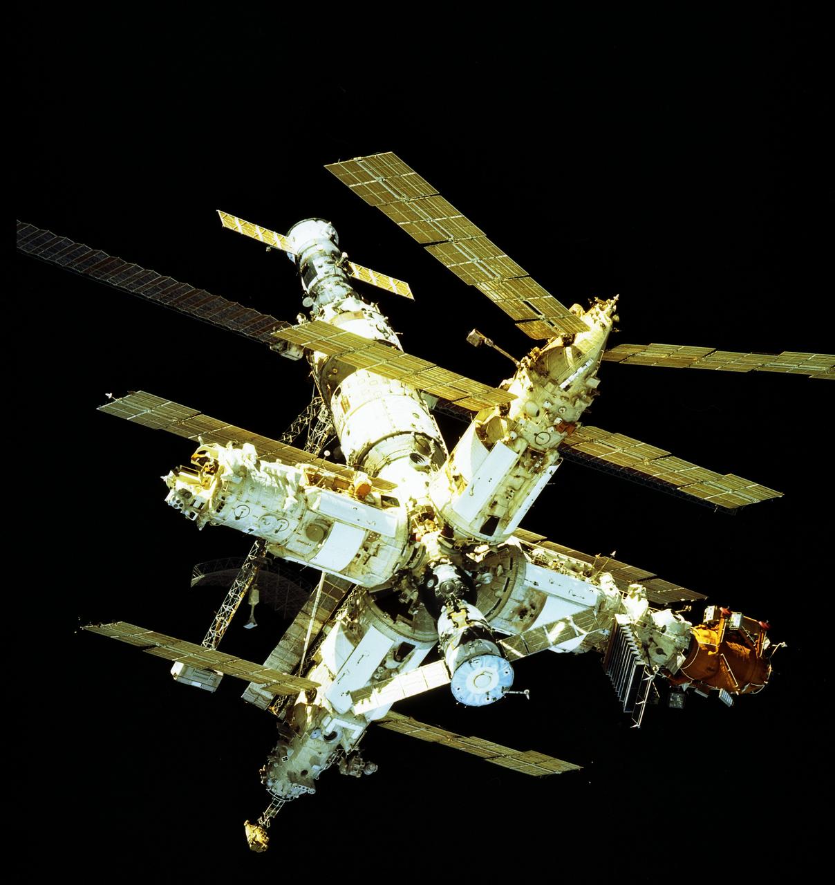 This is a view of the Russian Mir Space Station photographed by a crewmember of the fifth Shuttle/Mir docking mission, STS-81. The image shows: upper center - Progress supply vehicle, Kvant-1 module, and Core module; center left - Priroda module; center right - Spektr module; bottom left - Kvant-2 module; bottom center - Soyuz; and bottom right - Kristall module and Docking module. The Progress was an unmarned, automated version of the Soyuz crew transfer vehicle, designed to resupply the Mir. The Kvant-1 provided research in the physics of galaxies, quasars, and neutron stars, by measuring electromagnetic spectra and x-ray emissions. The Core module served as the heart of the space station and contained the primary living and working areas, life support, and power, as well as the main computer, communications, and control equipment. Priroda's main purpose was Earth remote sensing. The Spektr module provided Earth observation. It also supported research into biotechnology, life sciences, materials science, and space technologies. American astronauts used the Spektr as their living quarters. Kvant-2 was a scientific and airlock module, providing biological research, Earth observations, and EVA (extravehicular activity) capability. The Soyuz typically ferried three crewmembers to and from the Mir. A main purpose of the Kristall module was to develop biological and materials production technologies in the space environment. The Docking module made it possible for the Space Shuttle to dock easily with the Mir. The journey of the 15-year-old Russian Mir Space Station ended March 23, 2001, as the Mir re-entered the Earth's atmosphere and fell into the south Pacific Ocean.