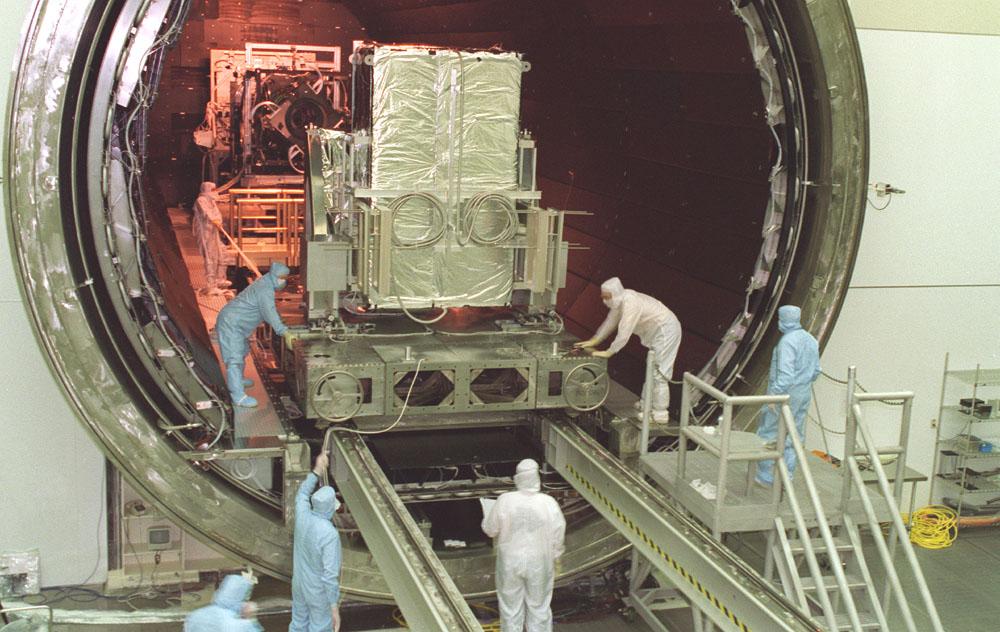 This photograph captures the installation of the Chandra X-Ray Observatory, formerly Advanced X-Ray Astrophysics Facility (AXAF), Advanced Charged-Coupled Device (CCD) Imaging Spectrometer (ACIS) into the Vacuum Chamber at the X-Ray Calibration Facility (XRCF) at Marshall Space Flight Center (MSFC). The AXAF was renamed Chandra X-Ray Observatory (CXO) in 1999. The CXO is the most sophisticated and the world's most powerful x-ray telescope ever built. It observes x-rays from high-energy regions of the universe, such as hot gas in the remnants of exploded stars. The ACIS is one of two focal plane instruments. As the name suggests, this instrument is an array of CCDs similar to those used in a camcorder. This instrument will be especially useful because it can make x-ray images and measure the energies of incoming x-rays. It is the instrument of choice for studying the temperature variation across x-ray sources, such as vast clouds of hot-gas intergalactic space. MSFC's XRCF is the world's largest, most advanced laboratory for simulating x-ray emissions from distant celestial objects. It produces a space-like environment in which components related to x-ray telescope imaging are tested and the quality of their performances in space is predicted. TRW, Inc. was the prime contractor for the development of the CXO and NASA's MSFC was responsible for its project management. The Smithsonian Astrophysical Observatory controls science and flight operations of the CXO for NASA from Cambridge, Massachusetts. The CXO was launched July 22, 1999 aboard the Space Shuttle Columbia (STS-93).