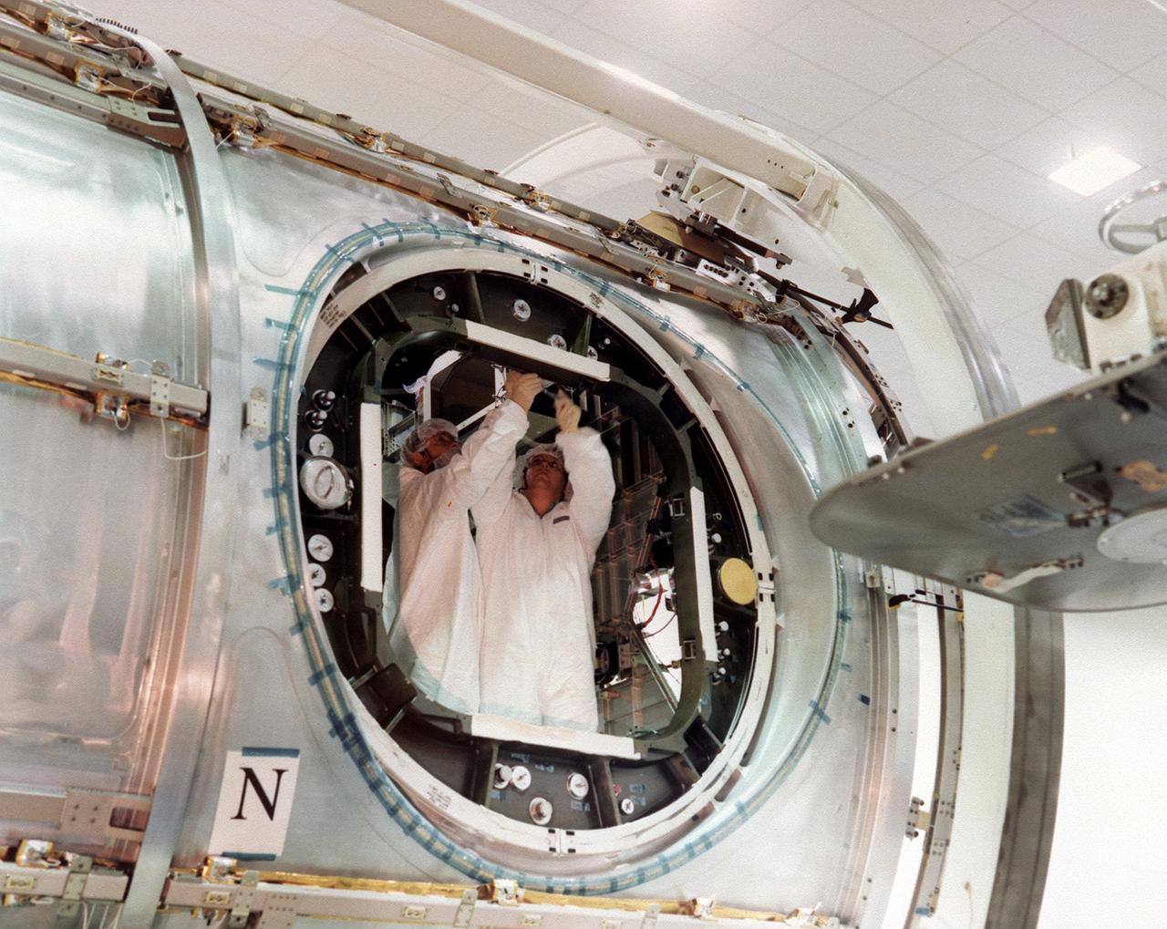 This photograph, taken by the Boeing Company, shows Boeing technicians preparing to install one of six hatches or doors to the Node 1 (also called Unity), the first U.S. Module for the International Space Station (ISS). The Node 1, or Unity, serves as a cornecting passageway to Space Station modules and was manufactured by the Boeing Company at the Marshall Space Flight Center from 1994 to 1997. The U.S. built Unity module was launched aboard the orbiter Endeavour (STS-88 mission) on December 4, 1998 and connected to the Zarya, the Russian-built Functional Energy Block (FGB). The Zarya was launched on a Russian proton rocket prior to the launch of the Unity. The ISS is a multidisciplinary laboratory, technology test bed, and observatory that will provide unprecedented undertakings in scientific, technological, and international experimentation.
