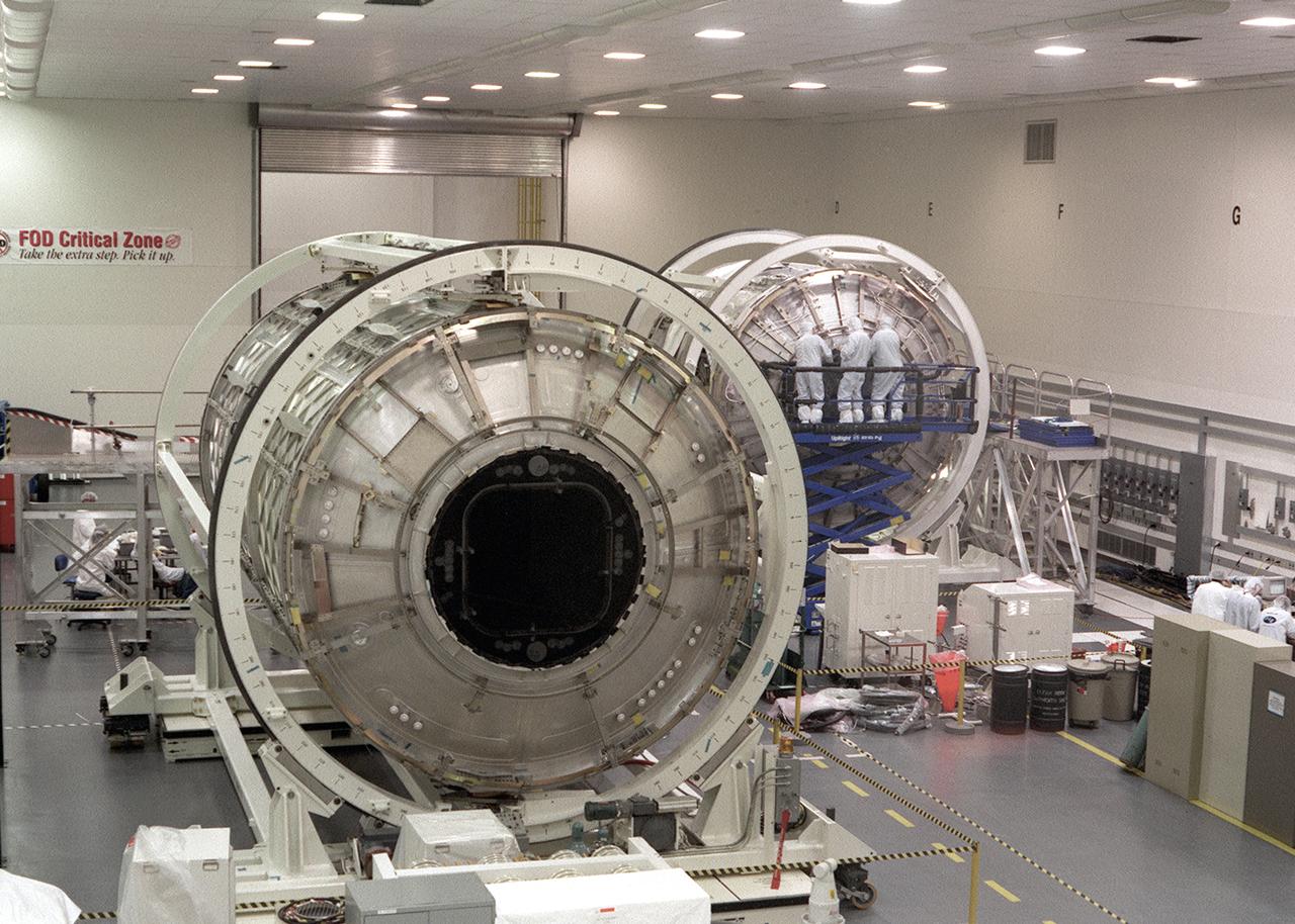 This Boeing photograph shows the Node 1, Unity module, Flight Article (at right) and the U.S. Laboratory module, Destiny, Flight Article for the International Space Station (ISS) being manufactured in the High Bay Clean Room of the Space Station Manufacturing Facility at the Marshall Space Flight Center. The Node 1, or Unity, serves as a cornecting passageway to Space Station modules. The U.S. built Unity module was launched aboard the orbiter Endeavour (STS-88 mission) on December 4, 1998 and connected to the Zarya, the Russian-built Functional Energy Block (FGB). The U.S. Laboratory (Destiny) module is the centerpiece of the ISS, where science experiments will be performed in the near-zero gravity of space. The U.S. Laboratory/Destiny was launched aboard the orbiter Atlantis (STS-98 mission) on February 7, 2001. The ISS is a multidisciplinary laboratory, technology test bed, and observatory that will provide unprecedented undertakings in scientific, technological, and international experimentation.