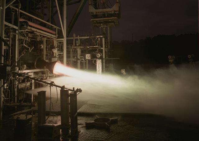 This is a photo of an X-34 40K Fastrac II duration test performed at the Marshall Space Flight Center test stand 116 (TS116) in June 1997. Engine ignition is started with Tea-Gas which makes the start burn green. The X-34 program was cancelled in 2001.