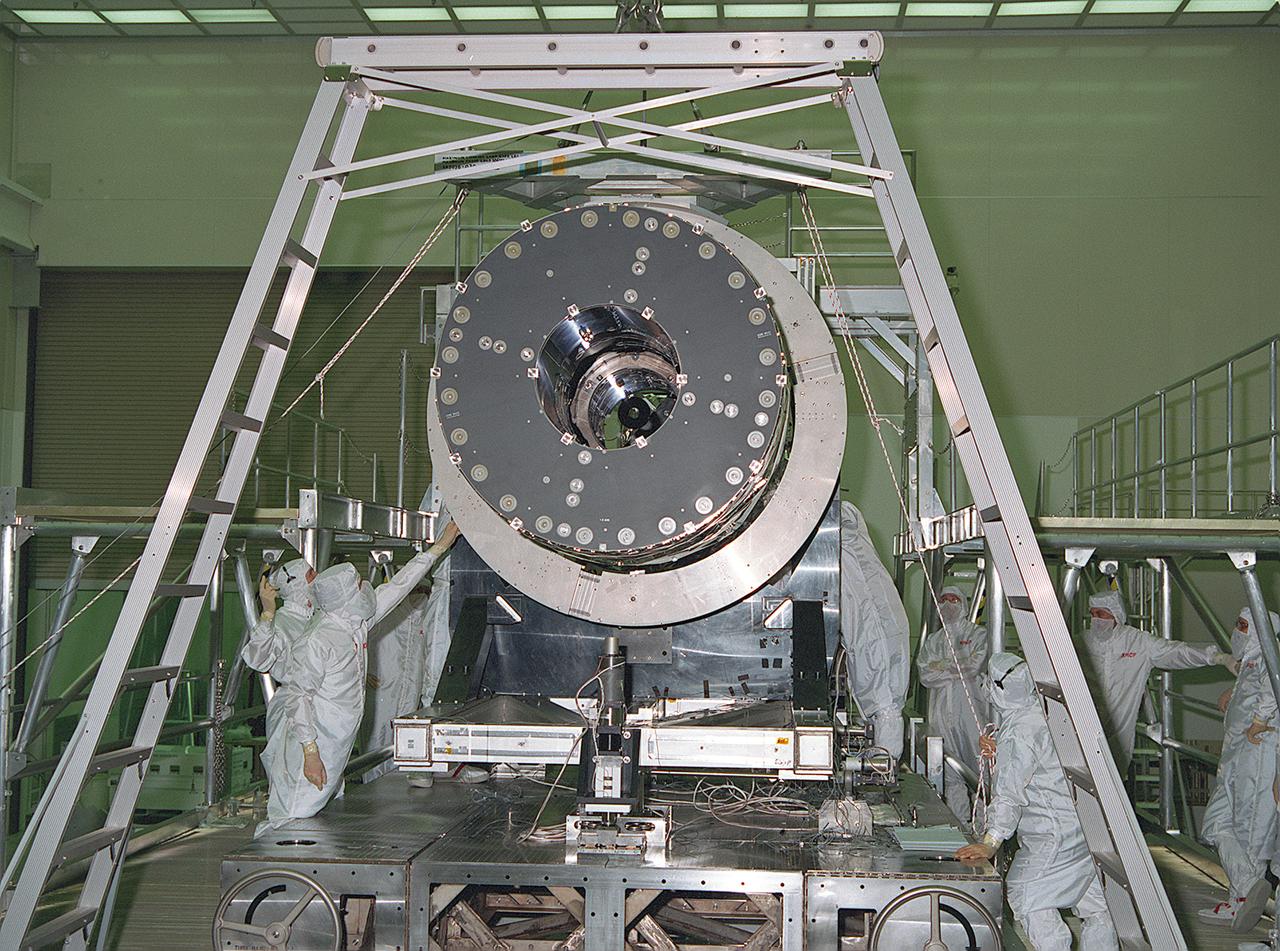 This photograph shows the Chandra X-Ray Observatory (CXO), formerly Advanced X-Ray Astrophysics Facility (AXAF), High Resolution Mirror Assembly (HRMA) being removed from the test structure in the X-Ray Calibration Facility (XRCF) at the Marshall Space Flight Center (MSFC). The AXAF was renamed CXO in 1999. The CXO is the most sophisticated and the world's most powerful x-ray telescope ever built. It observes x-rays from high-energy regions of the universe, such as hot gas in the remnants of exploded stars. The HRMA, the heart of the telescope system, is contained in the cylindrical "telescope" portion of the observatory. Since high-energy x-rays would penetrate a normal mirror, special cylindrical mirrors were created. The two sets of four nested mirrors resemble tubes within tubes. Incoming x-rays graze off the highly polished mirror surface and are furneled to the instrument section for detection and study. MSFC's XRCF is the world's largest, most advanced laboratory for simulating x-ray emissions from distant celestial objects. It produces a space-like environment in which components related to x-ray telescope imaging are tested and the quality of their performances in space is predicted. TRW, Inc. was the prime contractor for the development of the CXO and NASA's MSFC was responsible for its project management. The Smithsonian Astrophysical Observatory controls science and flight operations of the CXO for NASA from Cambridge, Massachusetts. The CXO was launched July 22, 1999 aboard the Space Shuttle Columbia (STS-93).