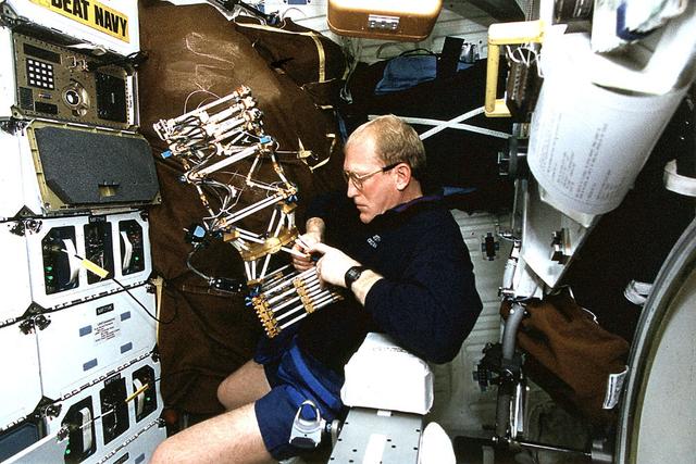 Onboard Space Shuttle Columbia (STS-62) Mission specialist Charles D. (Sam) Gemar works with the Middeck 0-Gravity Dynamics Experiment (MODE). The reusable test facility is designed to study the nonlinear, gravity-dependent behavior of liquids and skewed space structures in the microgravity environment.