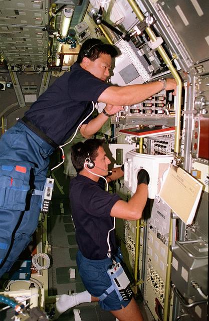 Onboard Space Shuttle Columbia (STS-65) Mission Specialist Leroy Chiao (top) and Mission Specialist Donald A. Thomas are seen at work in the International Microgravity Laboratory 2 (IML-2) spacelab science module. The two crewmembers are conducting experiments at the IML-2 Rack 5 Biorack (BR). Chiao places a sample in the BR incubator as Thomas handles another sample inside the BR glovebox. The glovebox is used to prepare samples for BR and slow rotating centrifuge microscope (NIZEMI) experiments.