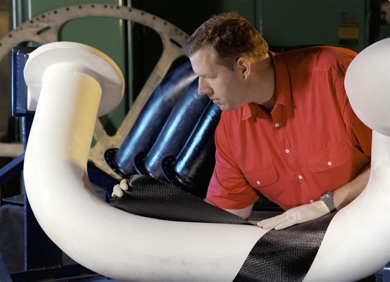 Engineers at Marshall Space Flight Center (MSFC) in Huntsville, Alabama, are working with industry partners to develop a new generation of more cost-efficient space vehicles. Lightweight fuel tanks and components under development will be the critical elements in tomorrow's reusable launch vehicles and will tremendously curb the costs of getting to space. In this photo, Tom DeLay, a materials processes engineer for MSFC, uses a new graphite epoxy technology to create lightweight cryogenic fuel lines for futuristic reusable launch vehicles. He is wrapping a water-soluble mandrel, or mold, with a graphite fabric coated with an epoxy resin. Once wrapped, the pipe will be vacuum-bagged and autoclave-cured. The disposable mold will be removed to reveal a thin-walled fuel line. In addition to being much lighter and stronger than metal, this material won't expand or contract as much in the extreme temperatures encountered by launch vehicles.