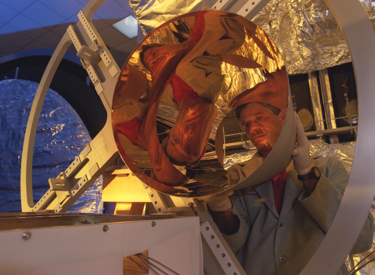 NASA's Space Optics Manufacturing Center has been working to expand our view of the universe via sophisticated new telescopes. The Optics Center's goal is to develop low-cost, advanced space optics technologies for the NASA program in the 21st century - including the long-term goal of imaging Earth-like planets in distant solar systems. To reduce the cost of mirror fabrication, Marshall Space Flight Center (MSFC) has developed replication techniques, the machinery and materials to replicate electro-formed nickel mirrors. The process allows fabricating precisely shaped mandrels to be used and reused as masters for replicating high-quality mirrors. This image shows a lightweight replicated x-ray mirror with gold coatings applied.