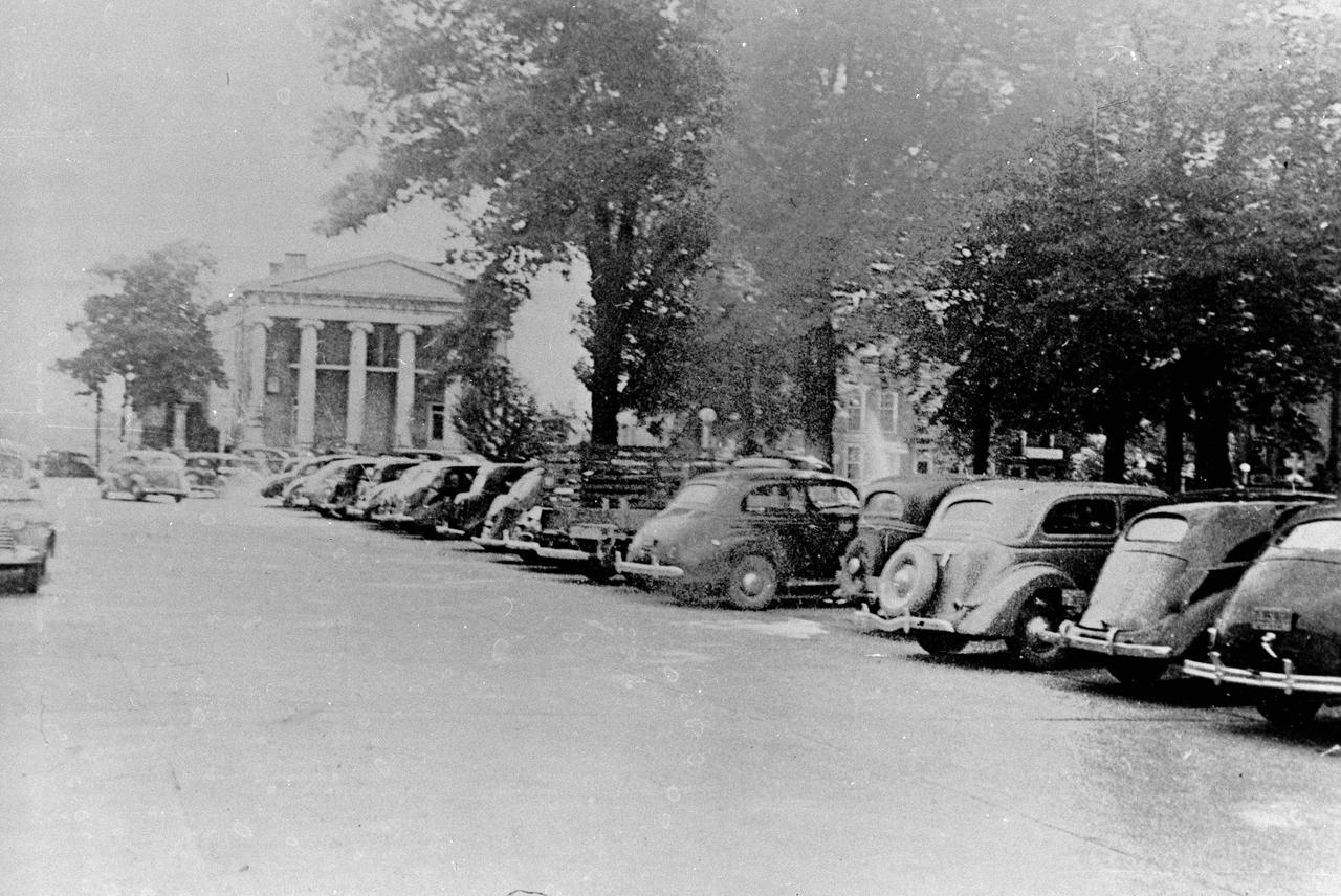 This 1940s photo of the South side of Square in downtown Huntsville, Alabama, looking west, shows a historical bank in the background with cars parked just South of the Courthouse (not shown in photo). (Courtesy of Huntsville/Madison County Public Library)