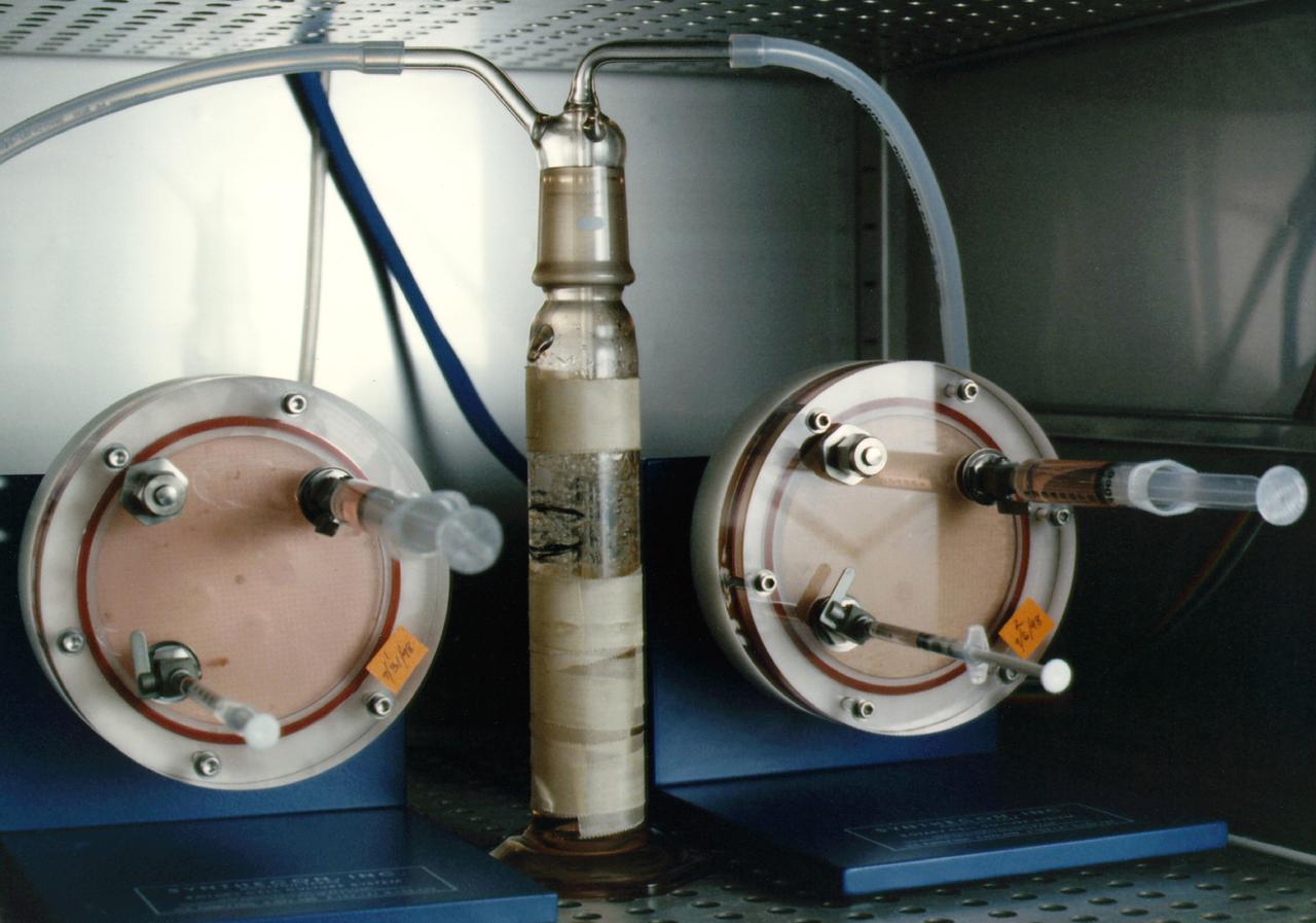 NASA's Marshall Space Flight Center (MSFC) is sponsoring research with Bioreactors, rotating wall vessels designed to grow tissue samples in space, to understand how breast cancer works. This ground-based work studies the growth and assembly of human mammary epithelial cells (HMEC) from breast cancer susceptible tissue. Radiation can make the cells cancerous, thus allowing better comparisons of healthy vs. tunourous tissues. Here, two High-Aspect Ratio Vessels turn at about 12 rmp to keep breast tissue constructs suspended inside the culture media. Syringes allow scientists to pull for analysis during growth sequences. The tube in the center is a water bubbler that dehumidifies the air to prevent evaporation of the media and thus the appearance of destructive bubbles in the bioreactor.
