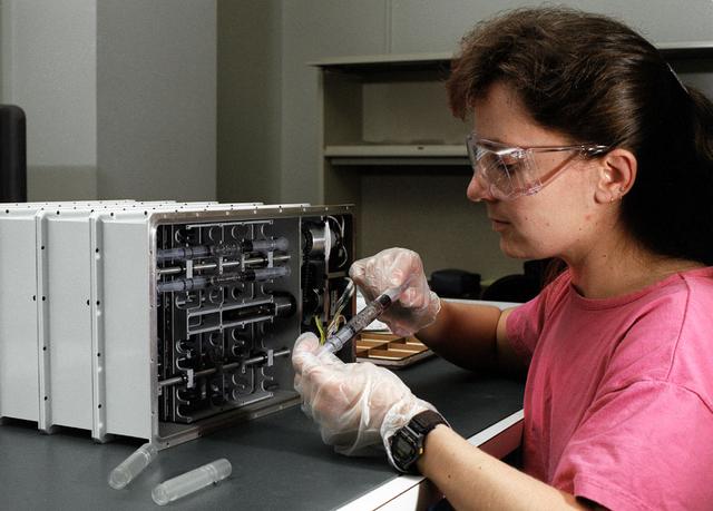 Karen Swofford working on Aerogel Syringe Assemblies loading process into mixing carriages of the Aerogel Flight Unit.