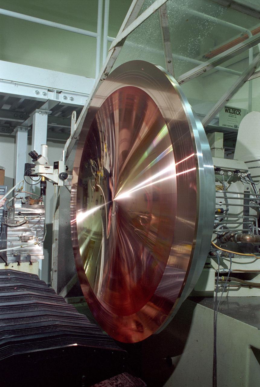 This king-size copper disk, manufactured at the Space Optics Manufacturing and Technology Center (SOMTC) at the Marshall Space Flight Center (MSFC), is a special mold for making high resolution monitor screens. This master mold will be used to make several other molds, each capable of forming hundreds of screens that have a type of lens called a Fresnel lens. Weighing much less than conventional optics, Fresnel lenses have multiple concentric grooves, each formed to a precise angle, that together create the curvature needed to focus and project images. MSFC leads NASA's space optics manufacturing technology development as a technology leader for diamond turning. The machine used to manufacture this mold is among many one-of-a-kind pieces of equipment of MSFC's SOMTC.