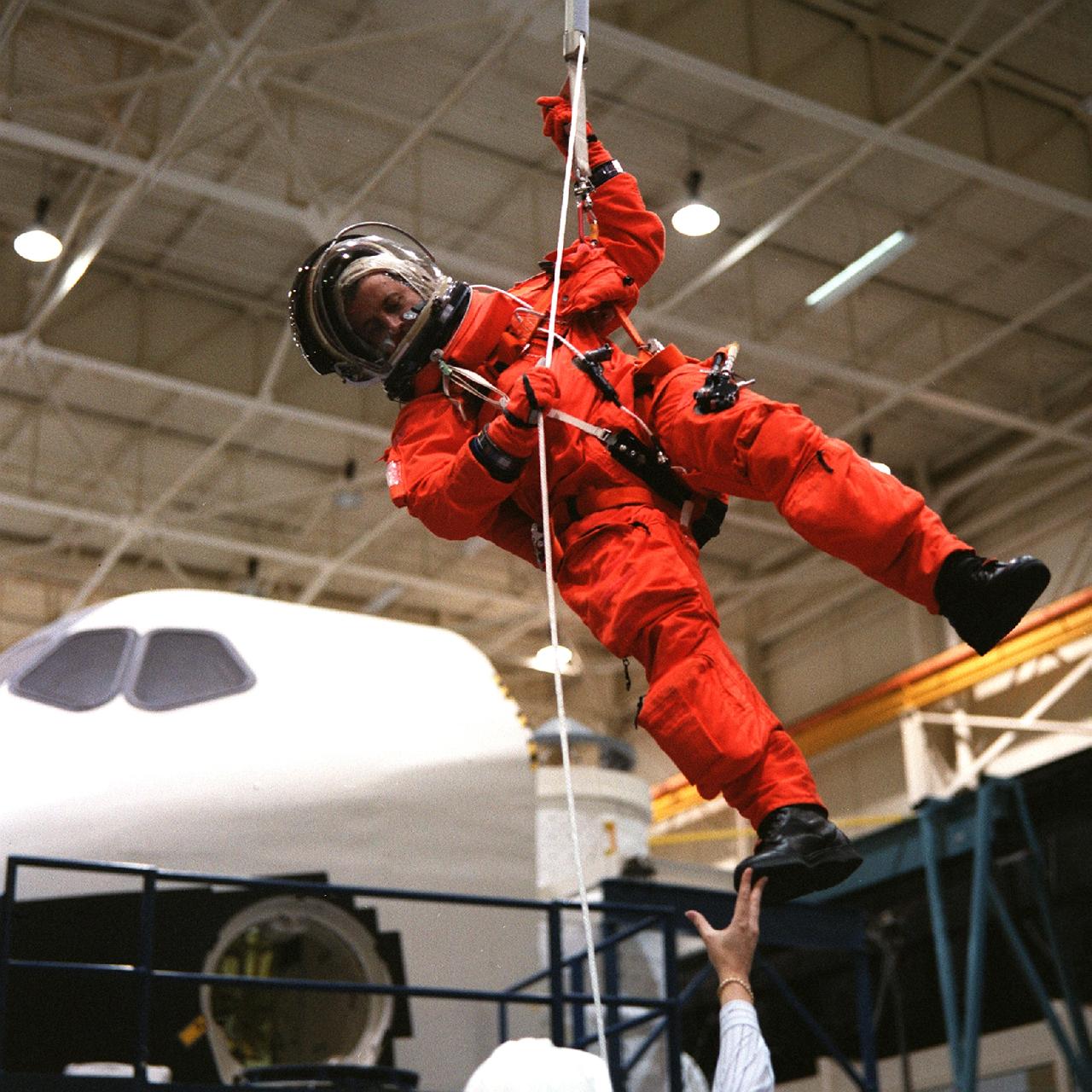 S98-09838 (6-29-98) --- Astronaut Michel Tognini lowers himself from a simulated  shuttle in trouble during an emergency egress training session in the Systems Integration Facility at the Johnson Space Center (JSC).  Tognini, a mission specialist representing France's Centre National d'Etudes Spatiales (CNES), will join four other astronauts for a scheduled five-day mission aboard the Space Shuttle Columbia in the spring of next year.