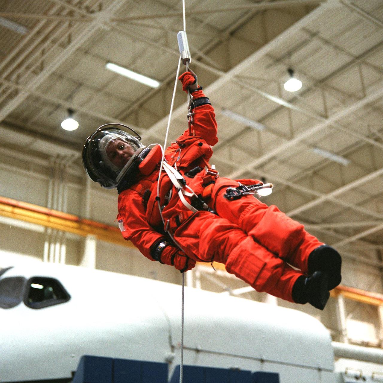 S98-09839 (6-29-98) --- Astronaut Eileen M. Collins lowers herself from a simulated shuttle in trouble during an emergency egress training session in the Systems Integration Facility at the Johnson Space Center (JSC).  Collins, mission commander for STS-93, will be joined by four other astronauts for a scheduled five-day mission aboard the Space Shuttle Columbia in the spring of next year.
