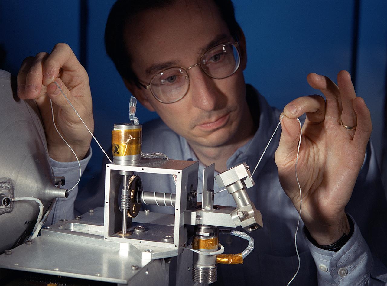 NASA's Propulsive Small Expendable Deployer System experiment (ProSEDS) will demonstrate the use of an electrodynamic tether, basically a long, thin wire, for propulsion. An electrodynamic tether uses the same principles as electric motors in toys, appliances and computer disk drives, and generators in automobiles and power plants. When electrical current is flowing through the tether, a magnetic field is produced that pushes against the magnetic field of the Earth. For ProSEDS, the current in the tether results by virtue of the voltage generated when the tether moves through the Earth's magnetic field at more than 17,000 mph. This approach can produce drag thrust generating useable power. Since electrodynamic tethers require no propellant, they could substantially reduce the weight of the spacecraft and provide a cost-effective method of reboosting spacecraft. The initial flight of ProSEDS is scheduled to fly aboard an Air Force Delta II rocket in the summer of 2002. In orbit, ProSEDS will deploy from a Delta II second stage. It will be a 3.1-mile (5 kilometer) long, ultrathin base-wire cornected with a 6.2-mile (10 kilometer) long nonconducting tether. This photograph shows Less Johnson, a scientist at MSFC inspecting the nonconducting part of a tether as it exits a deployer similar to the one to be used in the ProSEDS experiment. The ProSEDS experiment is managed by the Space Transportation Directorate at MSFC.