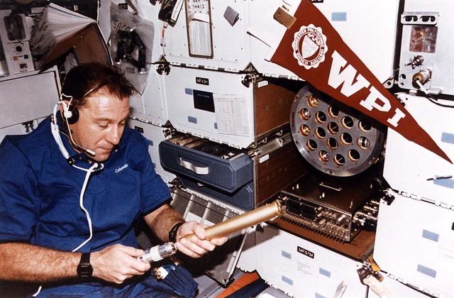 Payload specialist Albert Sacco Jr. inspects a crystal in a cylindrical autoclave on the mid-deck of the earth-orbiting space shuttle Columbia. This Zeolite Crystal Growth (ZCG) experiment was one of a few U.S. Microgravity Laboratory (USML-2) experiments that were conducted in both the Shuttle proper and its primary cargo's science module in the payload bay. Most of the experiments were conducted solely in the science module. Sacco was one of two guest researchers who joined five NASA astronauts for 16 days of Earth-orbit.