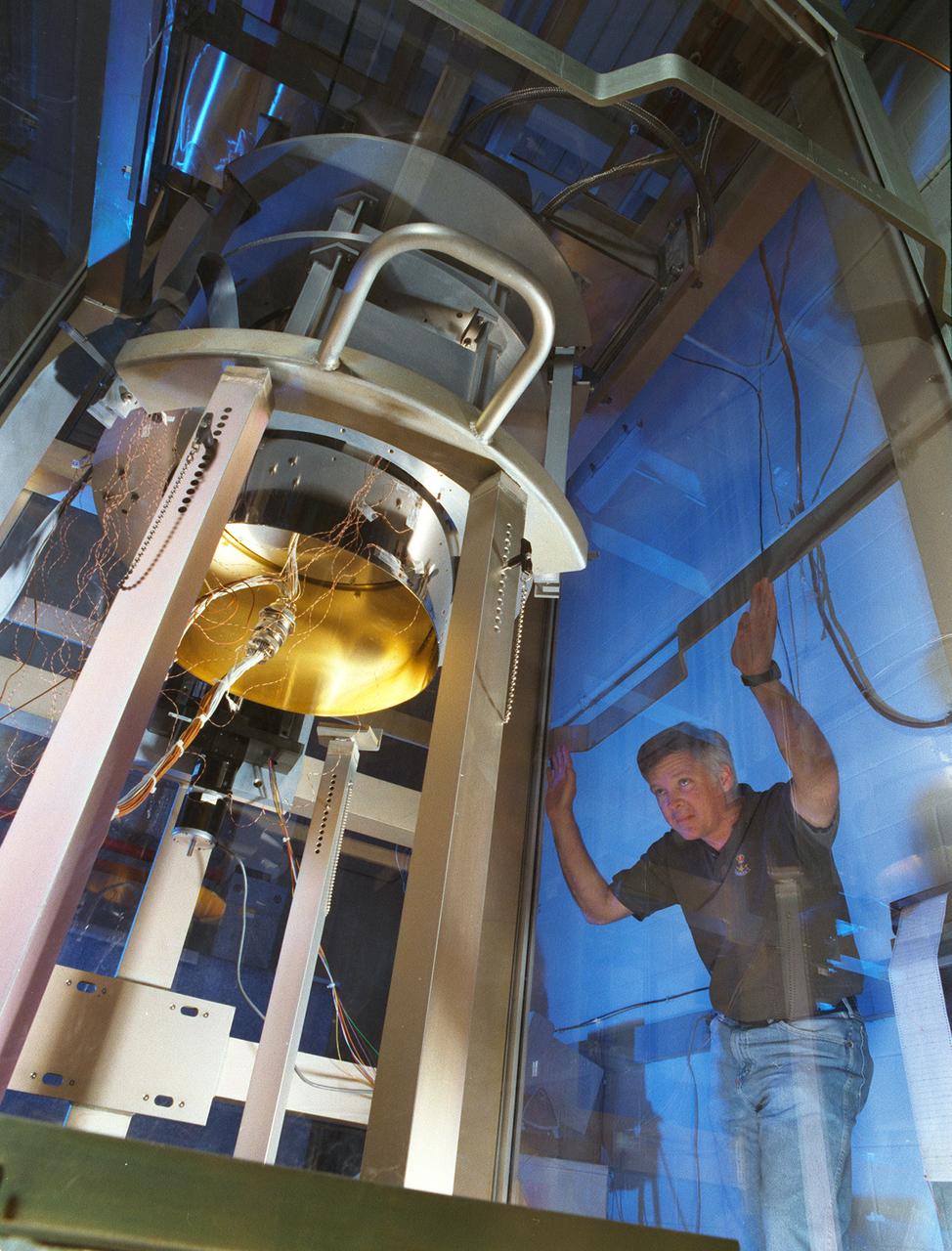 NASA's Space Optics Manufacturing Center has been working to expand our view of the universe via sophisticated new telescopes. The Optics Center's goal is to develop low-cost, advanced space optics technologies for the NASA program in the 21st century - including the long-term goal of imaging Earth-like planets in distant solar systems. To reduce the cost of mirror fabrication, Marshall Space Flight Center (MSFC) has developed replication techniques, the machinery, and materials to replicate electro-formed nickel mirrors. Optics replication uses reusable forms, called mandrels, to make telescope mirrors ready for final finishing. MSFC optical physicist Bill Jones monitors a device used to chill a mandrel, causing it to shrink and separate from the telescope mirror without deforming the mirror's precisely curved surface.