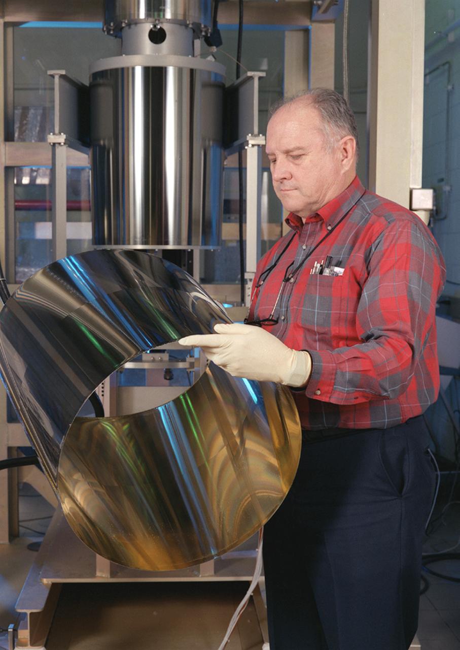 NASA's Space Optics Manufacturing Center has been working to expand our view of the universe via sophisticated new telescopes. The Optics Center's goal is to develop low-cost, advanced space optics technologies to the NASA program in the 21st century - including the long-term goal of imaging Earth-like planets in distant solar systems. To reduce the cost of mirror fabrication, Marshall Space Flight Center (MSFC) has developed replication techniques, the machinery, and materials to replicate electro-formed nickel mirrors. The process allows fabricating precisely shaped mandrels to be used and reused as masters for replicating high-quality mirrors. Photograph shows J.R. Griffith inspecting a replicated x-ray mirror mandrel.