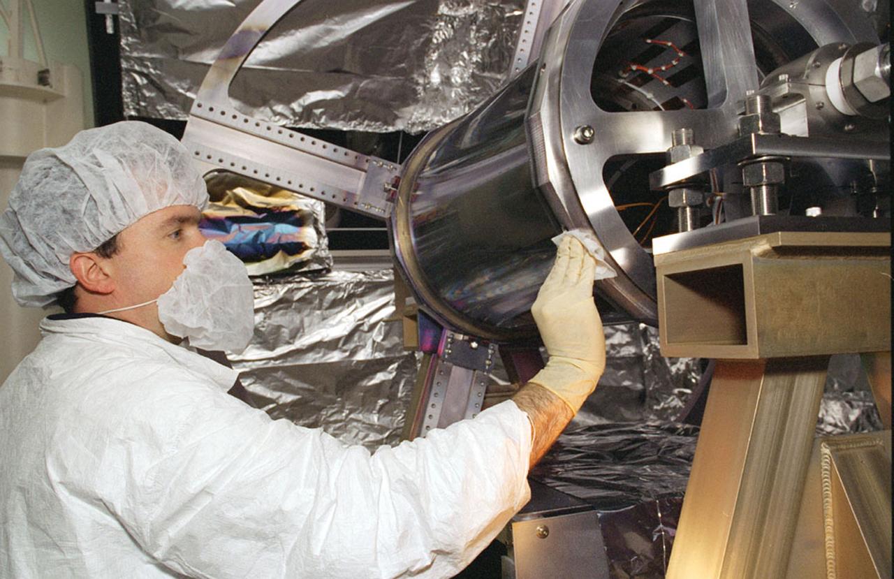 NASA's Space Optics Manufacturing Center has been working to expand our view of the universe via sophisticated new telescopes. The Optics Center's goal is to develop low-cost, advanced space optics technologies for the NASA program in the 21st century - including the long-term goal of imaging Earth-like planets in distant solar systems. To reduce the cost of mirror fabrication, Marshall Space Flight Center (MSFC) has developed replication techniques, the machinery, and materials to replicate electro-formed nickel mirrors. The process allows fabricating precisely shaped mandrels to be used and reused as masters for replicating high-quality mirrors. Image shows Dr. Alan Shapiro cleaning mirror mandrel to be applied with highly reflective and high-density coating in the Large Aperture Coating Chamber, MFSC Space Optics Manufacturing Technology Center (SOMTC).
