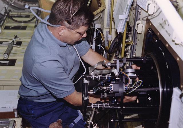 Astronaut Roger Crouch performs a change-out of the experiment in the Combustion Module-1 combustion chamber during STS-94.