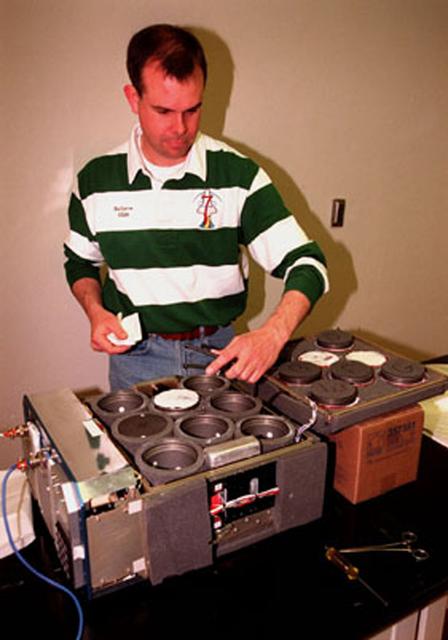 BioServe engineer Mark Rupert with the Version 3 Isothermal Containment Module containing the STS-93 experiment, NIH-B, being flown in cooperation with the National Institutes of Health (NIH).