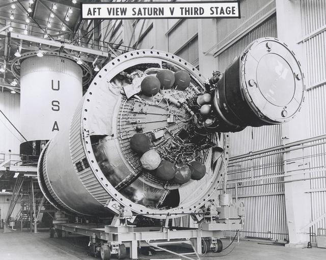 The powerful J-2 engine is prominent in this photograph of a Saturn V Third Stage (S-IVB) resting on a transporter in the Manufacturing Facility at Marshall Space Flight Center in Huntsville, Alabama. The towering 363-foot Saturn V was a multi-stage, multi-engine launch vehicle standing taller than the Statue of Liberty. Altogether, the Saturn V engines produced as much power as 85 Hoover Dams.