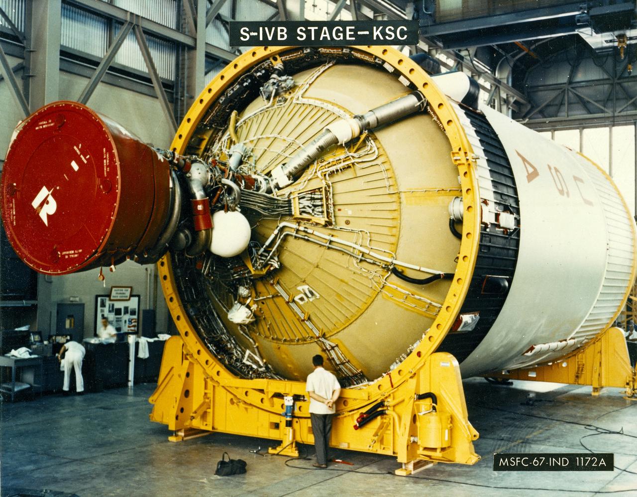 A NASA technician is dwarfed by the gigantic Third Stage (S-IVB) as it rests on supports in a facility at KSC. The towering 363-foot Saturn V was a multi-stage, multi-engine launch vehicle standing taller than the Statue of Liberty. Altogether, the Saturn V engines produced as much power as 85 Hoover Dams.