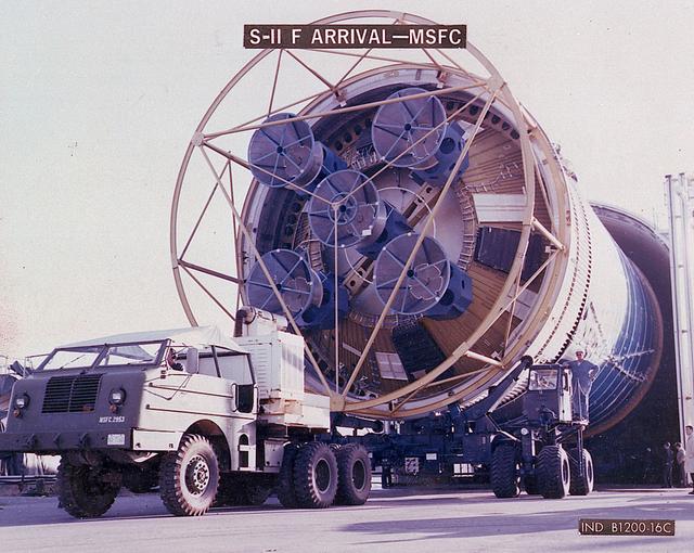 The business end of a Second Stage (S-II) slowly emerges from the shipping container as workers prepare to transport the Saturn V component to the testing facility at MSFC. The Second Stage (S-II) underwent vibration and engine firing tests. The towering 363-foot Saturn V was a multi-stage, multi-engine launch vehicle standing taller than the Statue of Liberty. Altogether, the Saturn V engines produced as much power as 85 Hoover Dams.